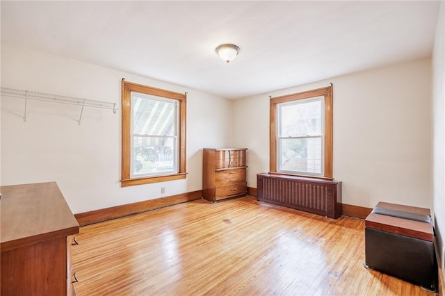 40 Mcnaughton St, Rochester, NY 14606 - unfurnished bedroom with radiator heating unit, multiple windows, wood finished floors, and baseboards