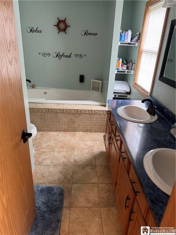 8900 Brownell Rd, Clymer, NY 14724 - bathroom featuring double vanity, a garden tub, and tile patterned floors