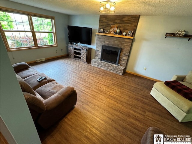8900 Brownell Rd, Clymer, NY 14724 - living room with a textured ceiling, baseboards, wood finished floors, and a fireplace