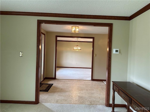 55 Hemlock Ln, Lancaster, NY 14086 - hallway with light carpet, a textured ceiling, baseboards, crown molding, and light tile patterned flooring