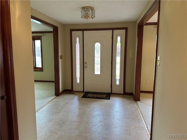 55 Hemlock Ln, Lancaster, NY 14086 - entrance foyer featuring a textured ceiling, baseboards, and light tile patterned floors