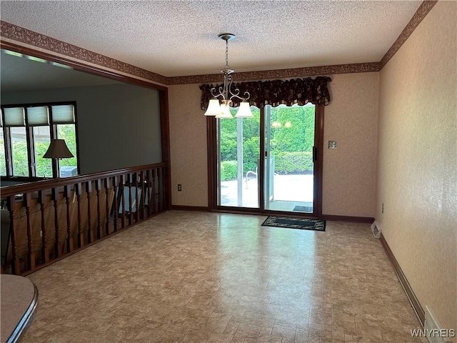 55 Hemlock Ln, Lancaster, NY 14086 - empty room featuring a textured wall, a textured ceiling, a chandelier, and baseboards