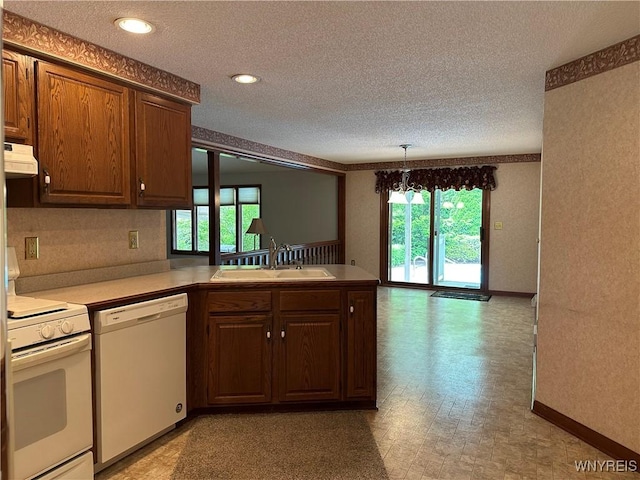 55 Hemlock Ln, Lancaster, NY 14086 - kitchen featuring white appliances, a sink, custom exhaust hood, a textured ceiling, and a peninsula