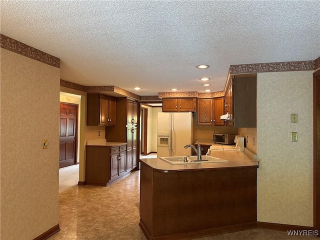 55 Hemlock Ln, Lancaster, NY 14086 - kitchen with white fridge with ice dispenser, a sink, a textured ceiling, a peninsula, and under cabinet range hood