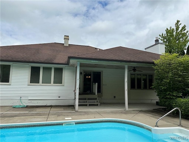55 Hemlock Ln, Lancaster, NY 14086 - back of house featuring a patio area, an outdoor pool, a shingled roof, ceiling fan, and a chimney