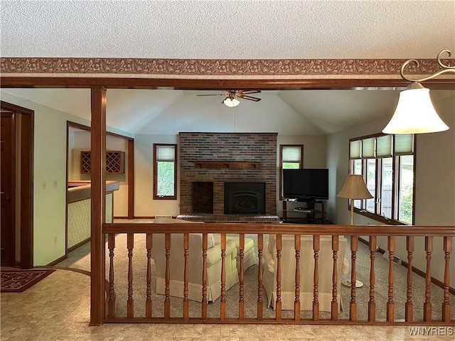 55 Hemlock Ln, Lancaster, NY 14086 - unfurnished living room with plenty of natural light, vaulted ceiling, a ceiling fan, a brick fireplace, and carpet floors