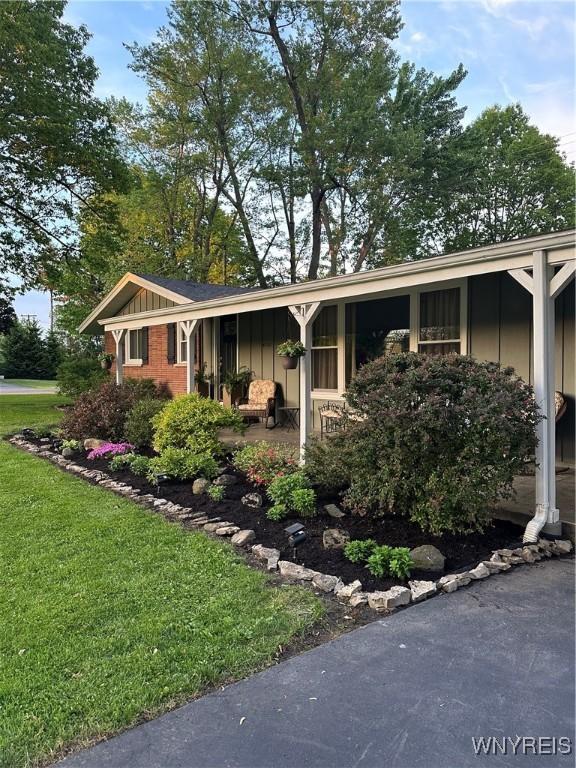4710 Boncrest Dr E, Clarence, NY 14221 - view of front of house with board and batten siding and a front yard