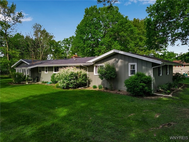 4710 Boncrest Dr E, Clarence, NY 14221 - view of front of property featuring board and batten siding, a front yard, and a chimney