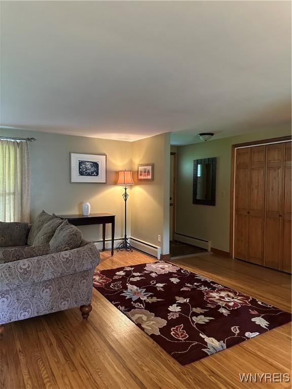 4710 Boncrest Dr E, Clarence, NY 14221 - living area with a baseboard radiator, light wood-style flooring, and baseboards