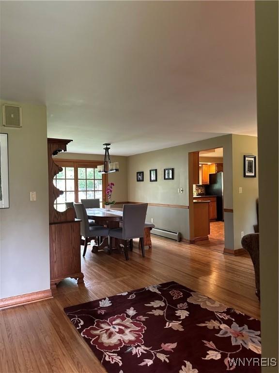 4710 Boncrest Dr E, Clarence, NY 14221 - dining room featuring a baseboard radiator, wood finished floors, and baseboards