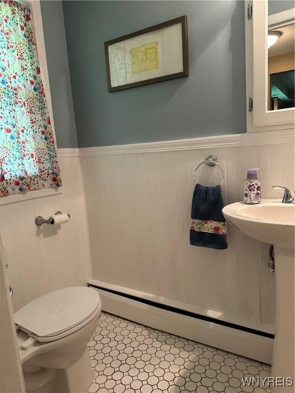 4710 Boncrest Dr E, Clarence, NY 14221 - half bath featuring a wainscoted wall, baseboard heating, toilet, and tile patterned flooring
