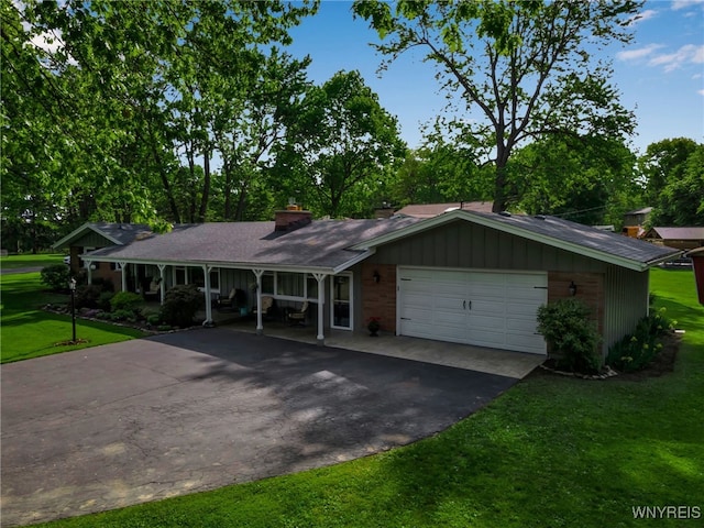 4710 Boncrest Dr E, Clarence, NY 14221 - single story home featuring asphalt driveway, a front yard, a garage, a porch, and a chimney