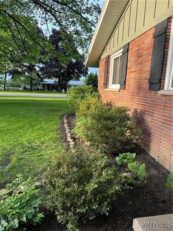 4710 Boncrest Dr E, Clarence, NY 14221 - view of home's exterior with brick siding, board and batten siding, and a lawn