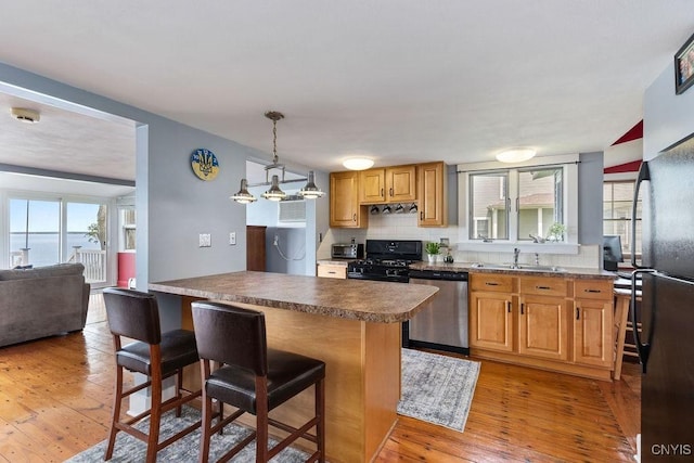 7649 Tuttle Rd, Cicero, NY 13030 - kitchen featuring dishwasher, black gas range oven, a sink, a kitchen breakfast bar, and plenty of natural light