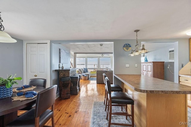 7649 Tuttle Rd, Cicero, NY 13030 - kitchen with light wood-type flooring, a center island, decorative light fixtures, a kitchen breakfast bar, and open floor plan