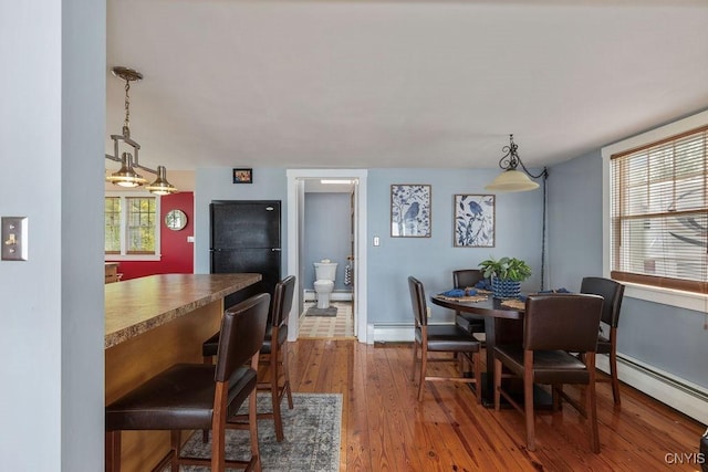 7649 Tuttle Rd, Cicero, NY 13030 - dining room featuring wood finished floors, baseboards, and a baseboard heating unit