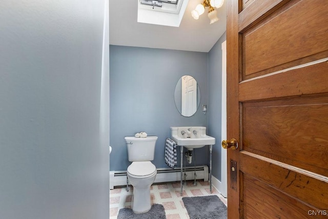 7649 Tuttle Rd, Cicero, NY 13030 - bathroom with a baseboard heating unit, a skylight, toilet, and baseboards