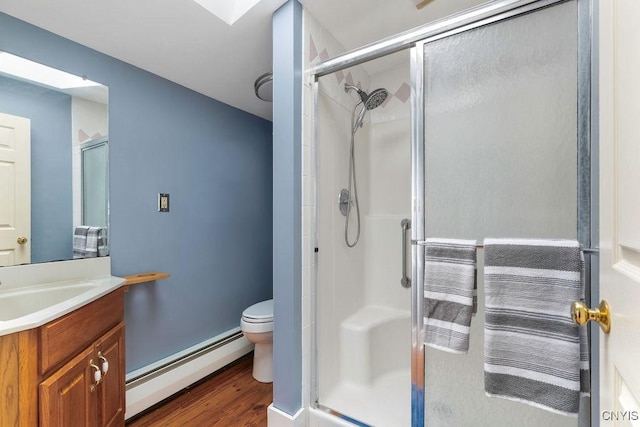 7649 Tuttle Rd, Cicero, NY 13030 - bathroom featuring a baseboard heating unit, toilet, a stall shower, wood finished floors, and vanity
