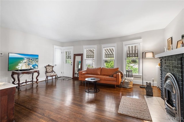 143 Lovering Ave, Buffalo, NY 14216 - living room featuring wood finished floors, baseboards, and a brick fireplace