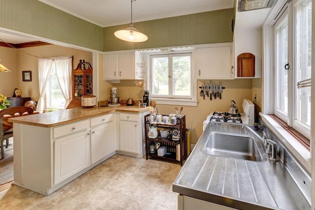 1031 Main St, Middletown, NY 12455 - kitchen featuring white gas stove, a sink, a peninsula, plenty of natural light, and ornamental molding