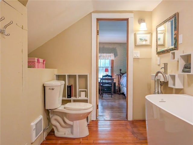 1031 Main St, Middletown, NY 12455 - bathroom with hardwood / wood-style flooring, a freestanding bath, toilet, and vaulted ceiling