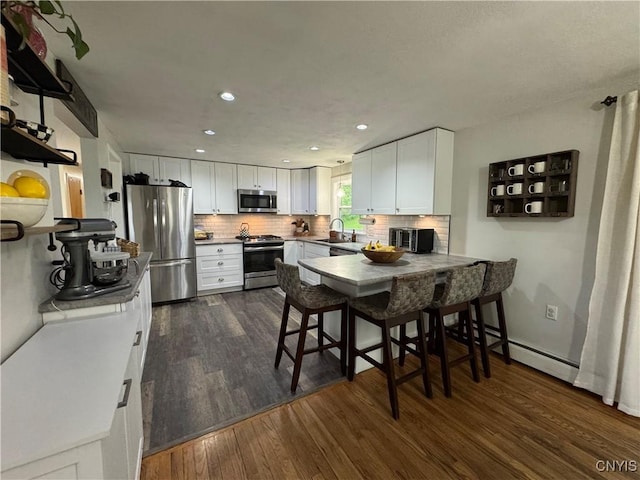 8521 Cazenovia Rd, Pompey, NY 13104 - kitchen with appliances with stainless steel finishes, dark wood-style flooring, a sink, white cabinetry, and recessed lighting