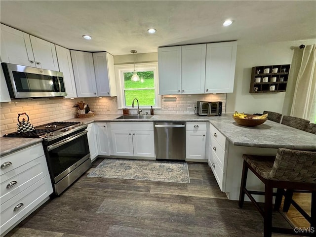 8521 Cazenovia Rd, Pompey, NY 13104 - kitchen with stainless steel appliances, a sink, a peninsula, a kitchen breakfast bar, and dark wood-style floors
