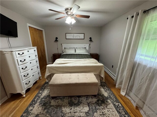 8521 Cazenovia Rd, Pompey, NY 13104 - bedroom with a baseboard heating unit, light wood-style floors, ceiling fan, and baseboards