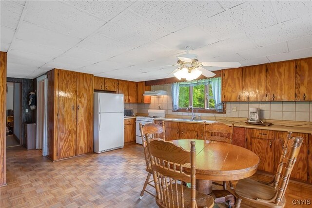 338 Dutch Hill Rd Unit 326, Parish, NY 13167 - kitchen featuring white appliances, a sink, ceiling fan, brown cabinets, and wood walls