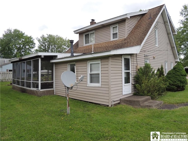 3931 S Ralph Ave, Ellery, NY 14712 - rear view of house with a sunroom, a chimney, a lawn, and a shingled roof