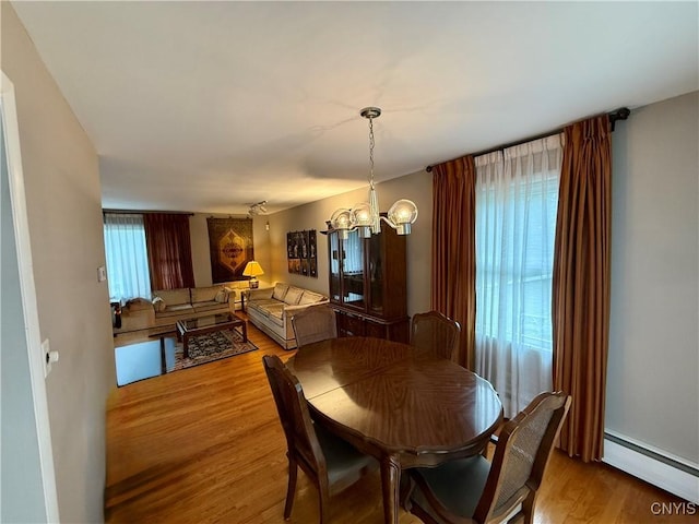 107 Rosewell Mdw, Dewitt, NY 13214 - dining space with a baseboard radiator, wood finished floors, and a chandelier