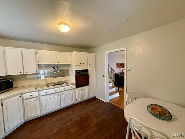 107 Rosewell Mdw, Dewitt, NY 13214 - kitchen featuring black oven, stainless steel microwave, dark wood-style floors, white cabinets, and cooktop