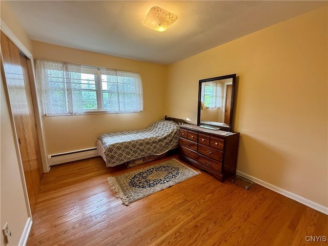107 Rosewell Mdw, Dewitt, NY 13214 - bedroom featuring a baseboard radiator, multiple windows, wood finished floors, and baseboards