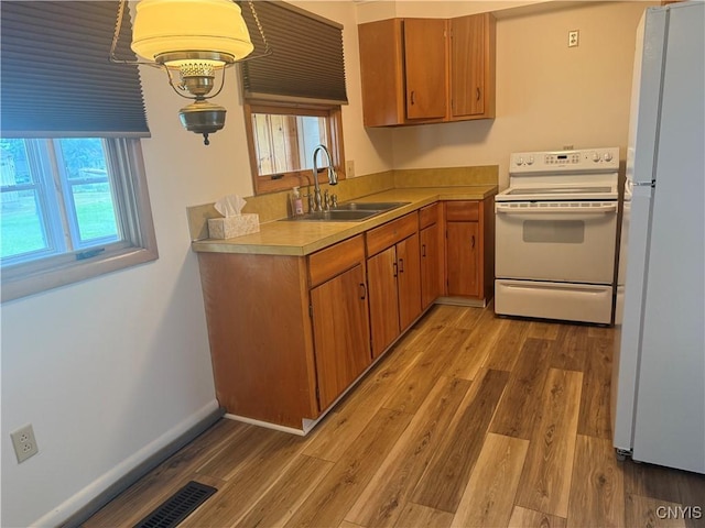 232 Millen Dr, Clay, NY 13212 - kitchen with white appliances, a sink, light countertops, light wood finished floors, and brown cabinetry