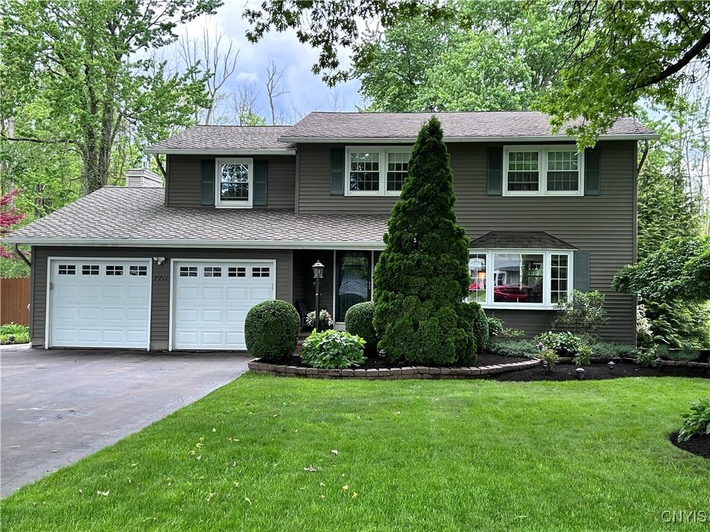 7711 Anchor Dr, Clay, NY 13090 - traditional-style house featuring asphalt driveway, a front lawn, and roof with shingles