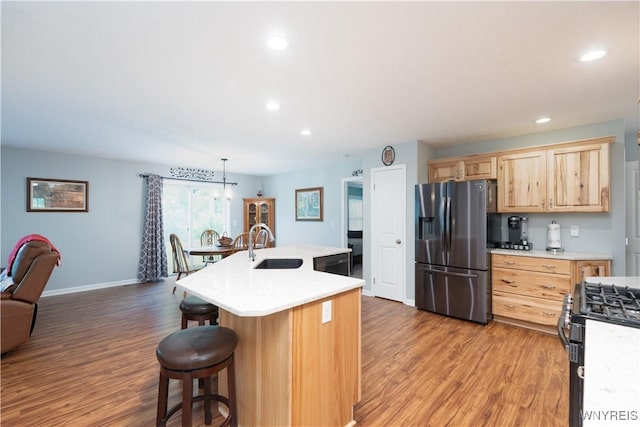 8484 Laura Ln, Richmond, NY 14471 - kitchen featuring appliances with stainless steel finishes, light brown cabinets, light countertops, light wood-style floors, and a kitchen bar
