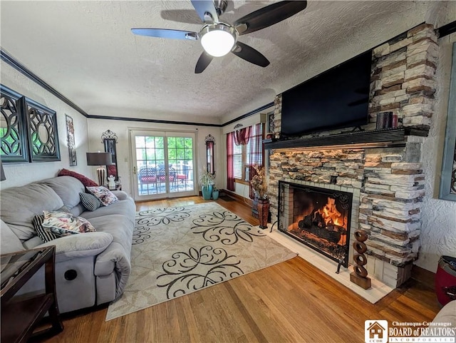 16 Ellis Ave, Jamestown, NY 14701 - living area featuring a stone fireplace, a textured ceiling, wood finished floors, ceiling fan, and crown molding