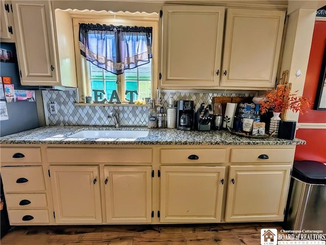 16 Ellis Ave, Jamestown, NY 14701 - kitchen featuring a sink, decorative backsplash, light stone countertops, and cream cabinets