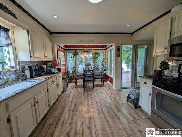 16 Ellis Ave, Jamestown, NY 14701 - kitchen featuring stainless steel appliances, backsplash, white cabinetry, light wood-type flooring, and light stone countertops