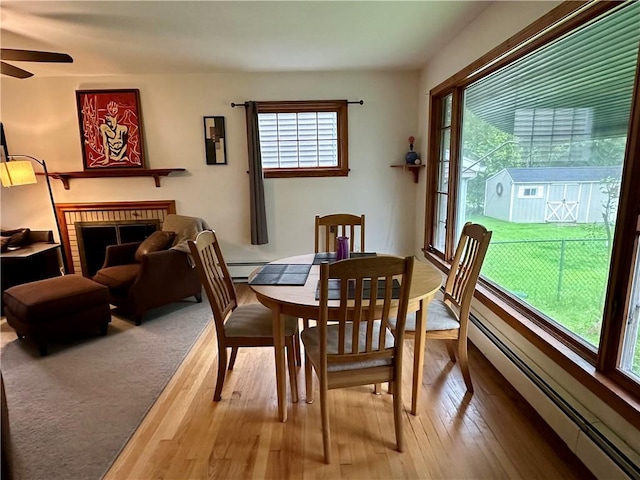 32 Bon Air Ave, Bradford-City, PA 16701 - dining room featuring baseboard heating, a fireplace, wood finished floors, and ceiling fan