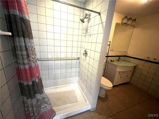 7290 State Route 80, Fabius, NY 13063 - bathroom with a tile shower, tile patterned floors, tile walls, vanity, and toilet