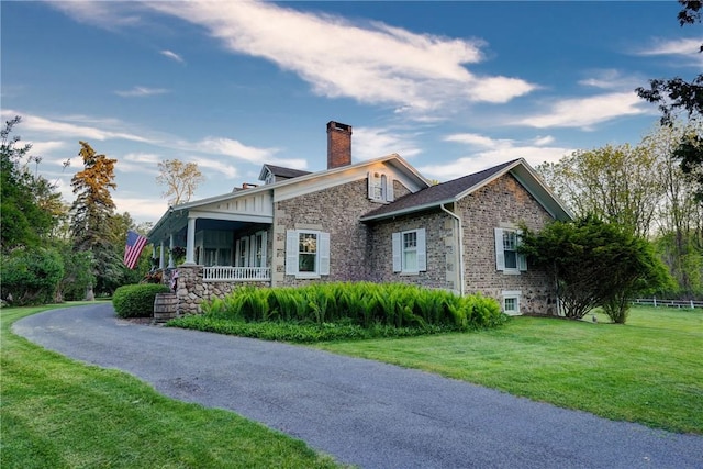 3402 W Lake Rd, Canandaigua Town, NY 14424 - view of home's exterior with a chimney, stone siding, a yard, and covered porch