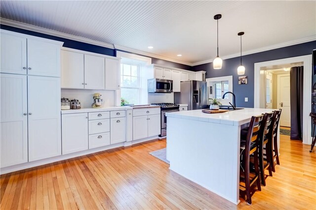 3402 W Lake Rd, Canandaigua Town, NY 14424 - kitchen with appliances with stainless steel finishes, crown molding, light countertops, light wood-style floors, and white cabinets