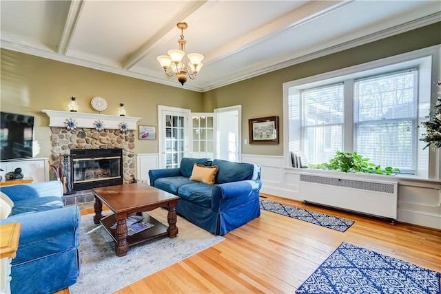 3402 W Lake Rd, Canandaigua Town, NY 14424 - living area featuring radiator heating unit, a fireplace, a chandelier, wood finished floors, and a wainscoted wall