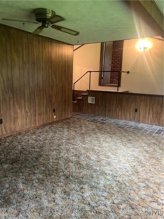 623 E Hamilton Ave N, Sherrill, NY 13461 - carpeted spare room with a ceiling fan and wood walls