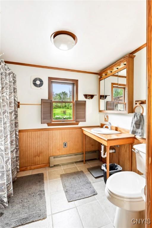 5549 State Route 104th Trl, Scriba, NY 13126 - bathroom with baseboard heating, a sink, a wainscoted wall, tile patterned floors, and toilet