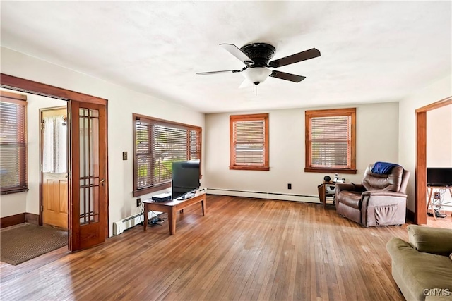 5549 State Route 104th Trl, Scriba, NY 13126 - living area featuring baseboard heating, hardwood / wood-style flooring, ceiling fan, and baseboards