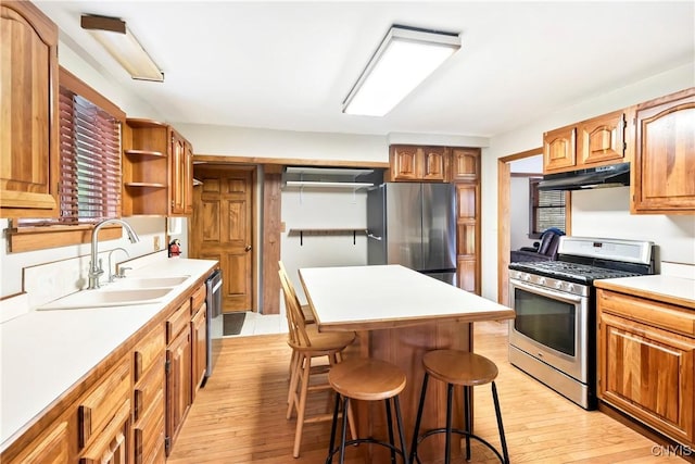 5549 State Route 104th Trl, Scriba, NY 13126 - kitchen featuring appliances with stainless steel finishes, a sink, under cabinet range hood, a kitchen bar, and light countertops