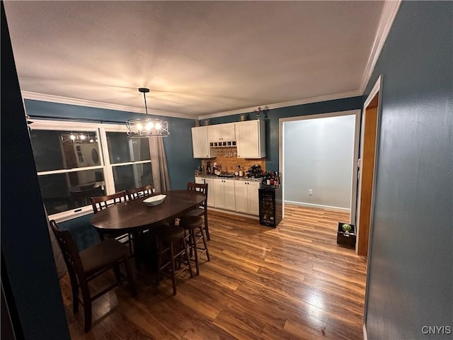 5030 Lincklaen Rd, Cuyler, NY 13158 - dining area featuring dark wood-type flooring, a bar, ornamental molding, and a chandelier