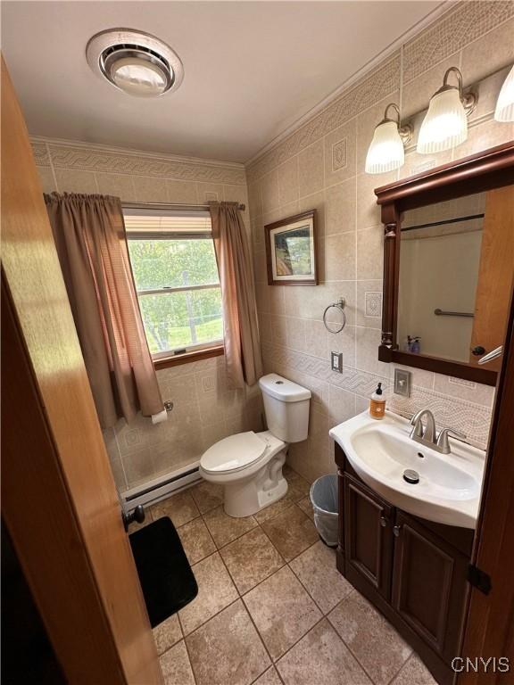 5030 Lincklaen Rd, Cuyler, NY 13158 - bathroom with toilet, a baseboard radiator, vanity, tile walls, and tile patterned flooring